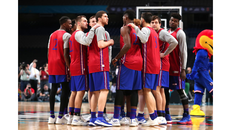 The Kansas Jayhawks huddle during practice 