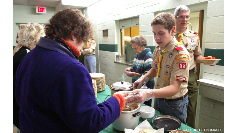 DES PLAINES, IL - JANUARY 5: Matthew Stieve of Boy Scout Troop 38 (2nd-R) serves soup to a guest at First United Methodist Church January 5, 2004 in Des Plaines, Illinois. Volunteers involved in a program called 'Bessie's Table' prepare and serve dinner to individuals or family members who are either unemployed, underemployed or just looking for a warm meal. Donations come from local grocery stores and other local companies. The program, which operates only on Monday evenings, serves an average of 70 people. (Photo by Tim Boyle/Getty Images)