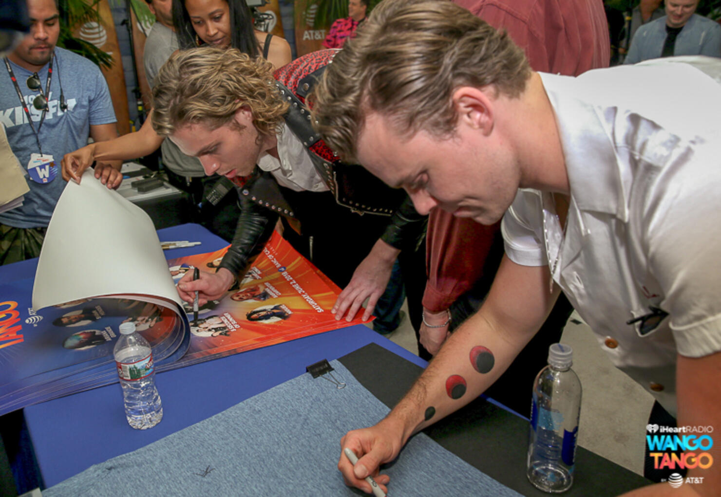 Luke Hemmings and Ashton Irwin of 5 Seconds of Summer sign posters backstage at the 2018 iHeartRadio Wango Tango by AT&T at Banc of California Stadium on June 2, 2018 in Los Angeles, California