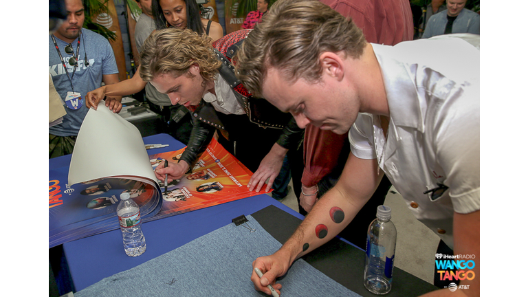 Luke Hemmings and Ashton Irwin of 5 Seconds of Summer sign posters backstage at the 2018 iHeartRadio Wango Tango by AT&T at Banc of California Stadium on June 2, 2018 in Los Angeles, California
