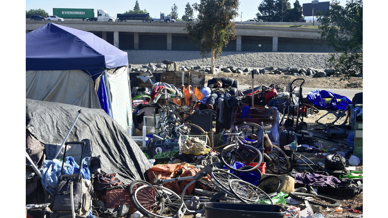 A homeless man (C) sleeps at a homeless encampment along the Santa Ana River beside Angel Stadium in Anaheim, California on January 23, 2018. January 22 reports said authorities planned to clear out Orange County's largest homeless encampment with some 500 people living in tents. Angel Stadium is home to Major League Baseball's Anaheim Angels. (Photo credit FREDERIC J. BROWN/AFP/Getty Images)