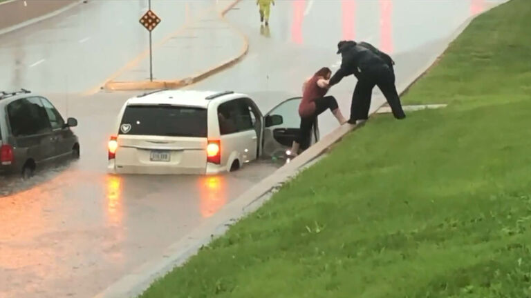 Rebecca Hovick helped out of her flooded vehicle by Ames police.  WHO TV