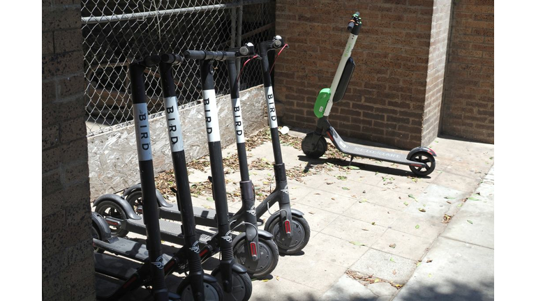 Shared electric scooters are parked on a street in Santa Monica, California, on July 13, 2018. - Cities across the U.S. are grappling with the growing trend of electric scooters which users can unlock with a smartphone app. Scooter startups including Bird and Lime allow riders to park them anywhere that doesn't block pedestrian walkways but residents in some cities, including Los Angeles, say they often litter sidewalks and can pose a danger to pedestrians. (Photo by Robyn Beck / AFP)