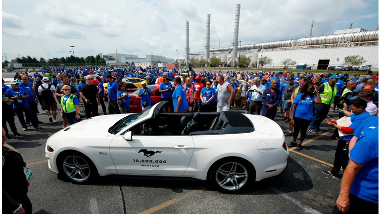 Employees surround Ford Motor's Mustang, the 10 millionth vehicle produced at their Flat Rock Assembly on August 8, 2018 in Flat Rock, Michigan. - The Ford Mustang -- an iconic American brand and a symbol of cool -- reached a major milestone Wednesday as the 10 millionth vehicle rolls off an assembly line at a Detroit-area plant. Ford marked the occasion for the car, celebrated in American song and film and recognized the world over as a quintessentially American cultural export, with a big party and parade at the Michigan headquarters. (Photo by JEFF KOWALSKY / AFP)