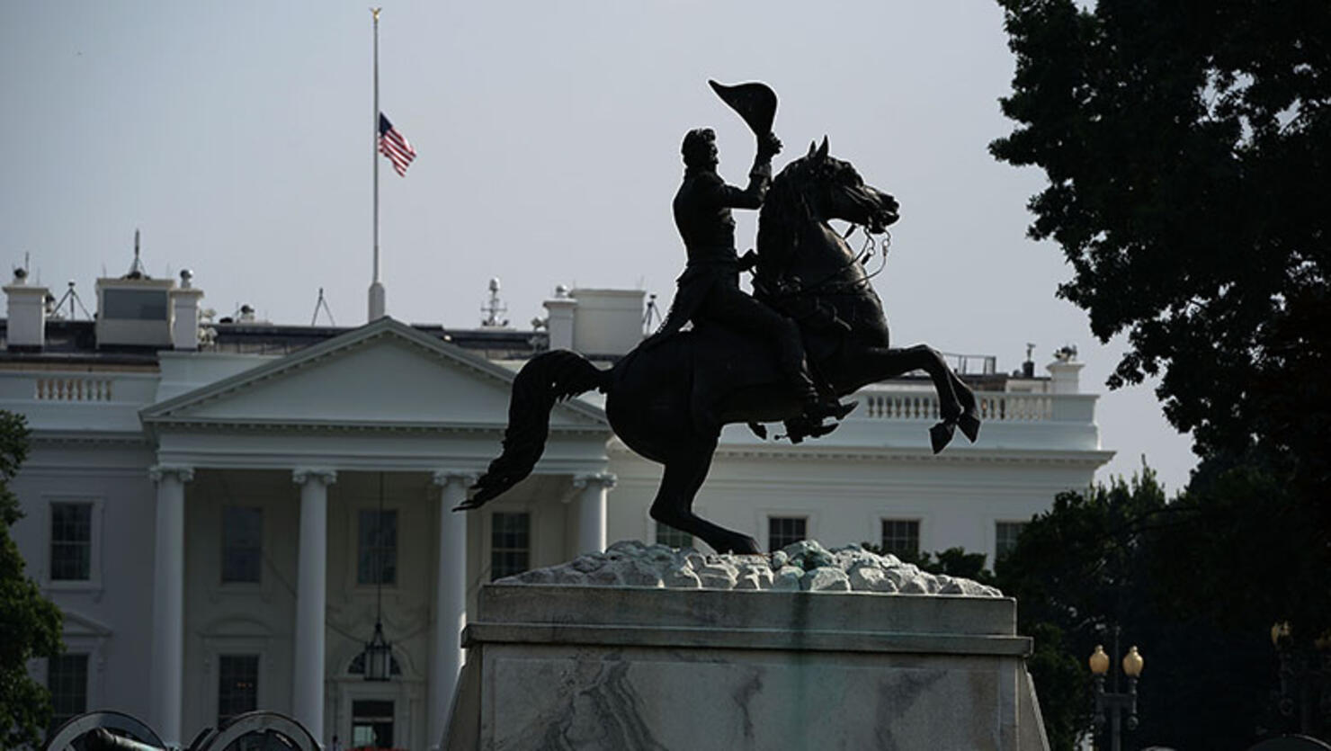 Seen behind the Andrew Jackson statue, the American flag at the White House flies at half staff