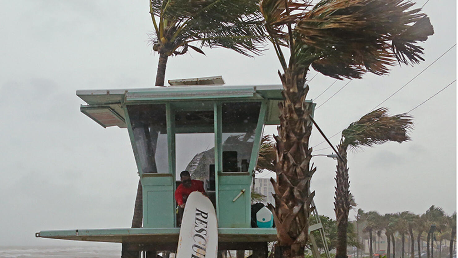 Dania Beach Ocean Rescue Alice Henley and Dillon Wise secure their surfboard as Tropical Storm Gordon passes by South Florida with wind gusts and heavy rainfall