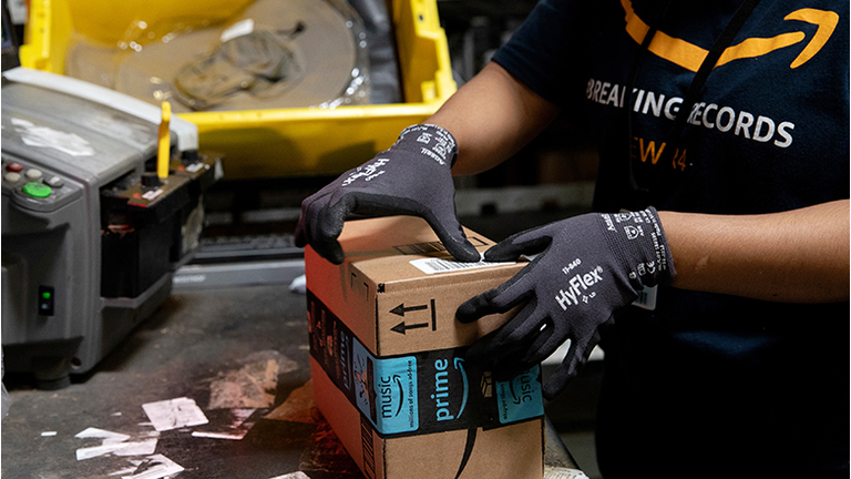 An employee packs a box at the Amazon.com Inc. fulfillment center