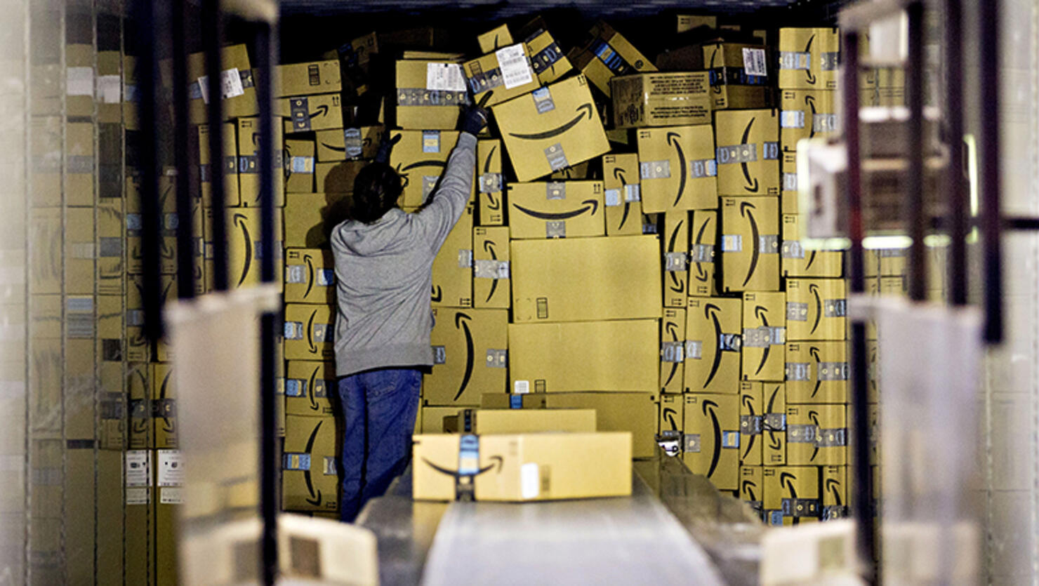 An employee unloads a truck load of Amazon.com Inc. packages