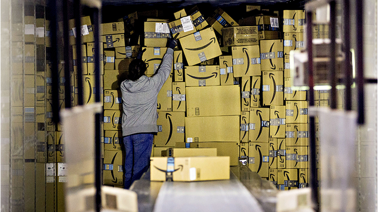 An employee unloads a truck load of Amazon.com Inc. packages