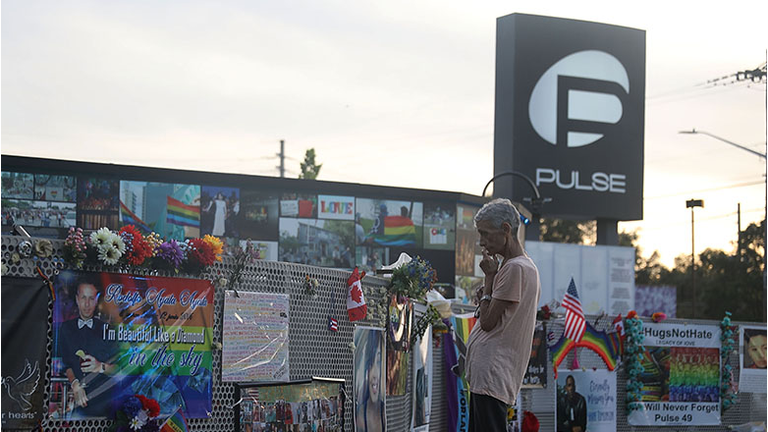 A visitor takes in the scene at the memorial to the 49 shooting victims setup at the Pulse nightclub where the shootings took place two years ago on June 12, 2018 in Orlando, Florida