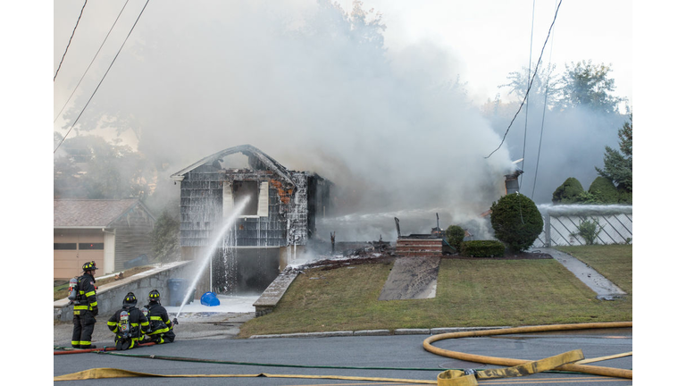 LAWRENCE, MA - SEPTEMBER 13: Firefighters work to extinguish a fire caused by over pressurized gas lines on September 13, 2018 in Lawrence, Massachusetts. Dozens of fires broke out in Lawrence, North Andover and Andover because of the gas lines. (Photo by Scott Eisen/Getty Images)