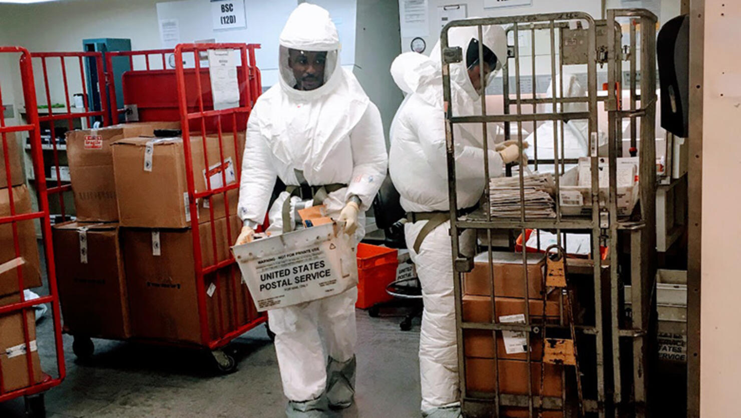 US Defense Department personnel, wearing protective suits, screen mail as it arrives at a US government facility near the Pentagon in Washington, DC on October 2, 2018. - Two or more packages delivered to the Pentagon this week were suspected to contain the deadly poison ricin