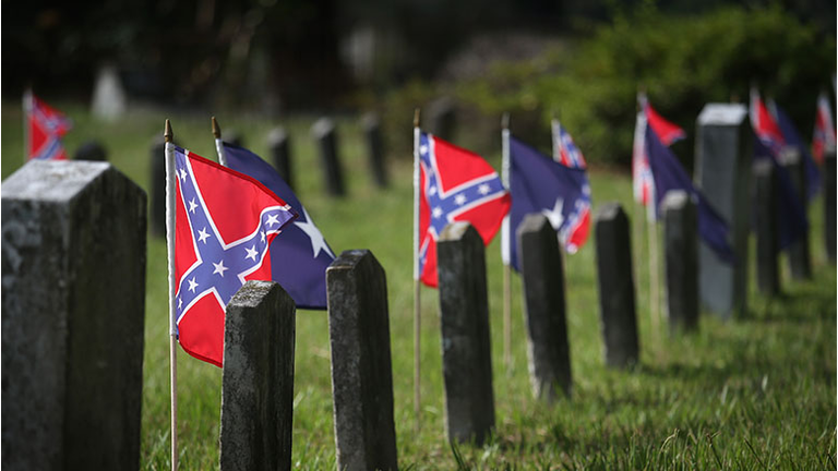 Confederate flags fly over the graves of Confederate soldiers buried in Magnolia Cemetery