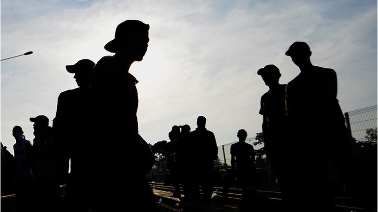 Migrants remain on the international border bridge between Guatemala and Mexico in Ciudad Tecun Uman, Guatemala, where a security fence close to the border has been reinforced a day after Honduran migrants tried to cross into Mexico