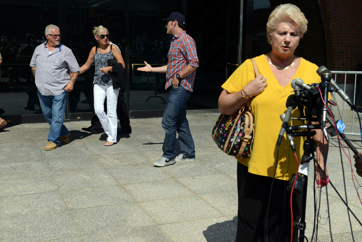 BOSTON - AUGUST 12: Patricia Donahue, wife of Michael Donahue, speaks to reporters as Steven Davis (L), brother of Debra Davis, walk by in background outside the John Joseph Moakley United Sates Courthouse following a guilty verdict against James 'Whitey' Bulger August 12, 2013 in Boston, Massachusetts. Bulger was found guilty on 31 of 32 counts of racketeering and acts related to murder. Bulger was convicted of the Michael Donahue murder while Debra Davis was the one murder that was found as 'No Finding.' (Photo by Darren McCollester/Getty Images)