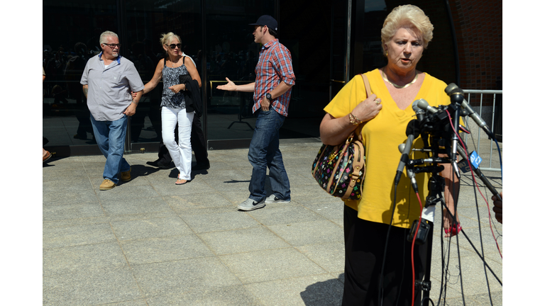 BOSTON - AUGUST 12: Patricia Donahue, wife of Michael Donahue, speaks to reporters as Steven Davis (L), brother of Debra Davis, walk by in background outside the John Joseph Moakley United Sates Courthouse following a guilty verdict against James 'Whitey' Bulger August 12, 2013 in Boston, Massachusetts. Bulger was found guilty on 31 of 32 counts of racketeering and acts related to murder. Bulger was convicted of the Michael Donahue murder while Debra Davis was the one murder that was found as 'No Finding.' (Photo by Darren McCollester/Getty Images)