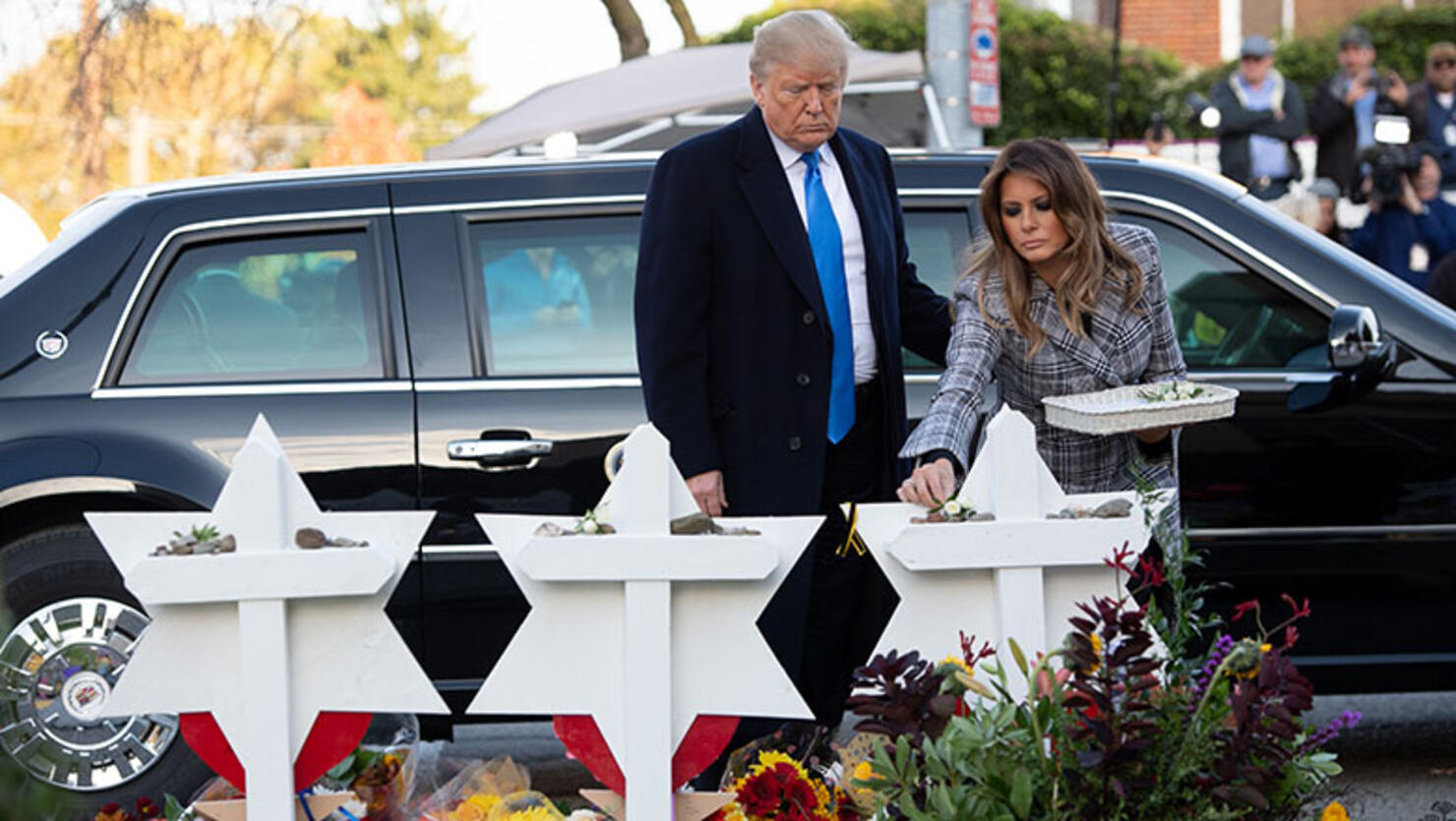 US President Donald Trump and First Lady Melania Trump, alongside Rabbi Jeffrey Myers, place stones and flowers on a memorial as they pay their respects at the Tree of Life Synagogue in Pittsburgh, Pennsylvania
