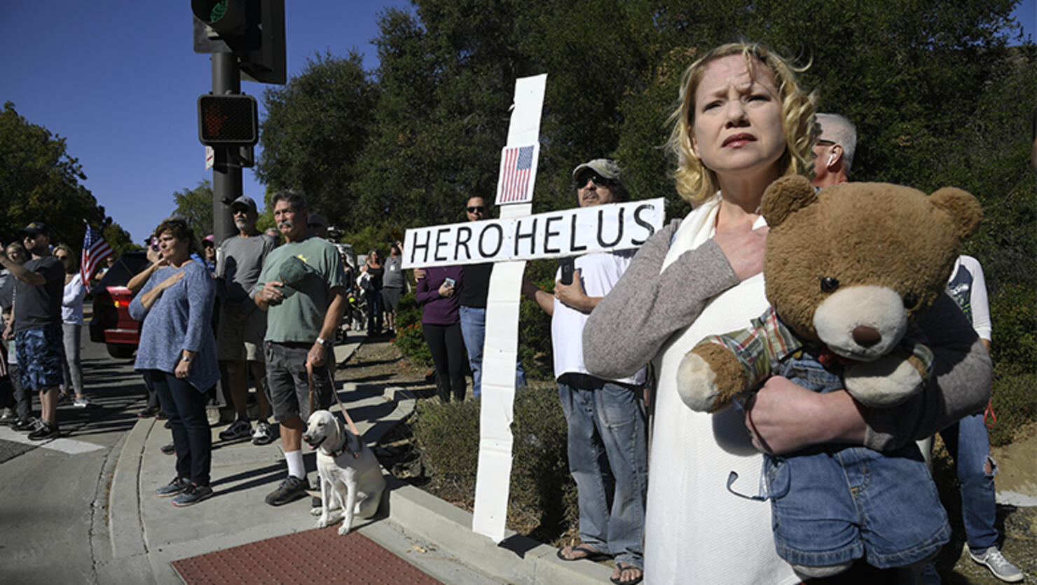 Brina Baird-Gerber holds her hand over her heart as the procession carrying the body of Ventura County Sheriff Sgt. Ron Helus, who was killed in a mass shooting at the Borderline Bar and Grill