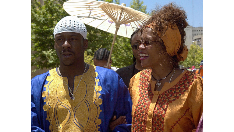 FILES-MIDEAST-ISRAEL-WHITNEY HOUSTON (FILES)US singer and actress Whitney Houston(R) smiles as she walks with her husband Bobby Brown next to the 'Wailing Wall' or Western Wall in the old city of Jerusalem 28 May 2003. The rocky marriage of Houston, whose popular tunes include 'Love is a Contact Sport,' has suffered another jolt after her husband, singer Bobby Brown. Brown was formally charged 10 December 2003 with beating her in the couple's home in a Atlanta suburb. Fulton County police spokesman Kurtis Young said the altercation inside the mansion near Alpharetta, Georgia, had forced the world-famous diva to plead for help in a frantic emergency call to police. The reason for the argument was not mentioned, but the marriage of 13 years has had a number of rough patches before. AFP PHOTO/STR / AFP PHOTO (Photo credit should read /AFP/Getty Images)