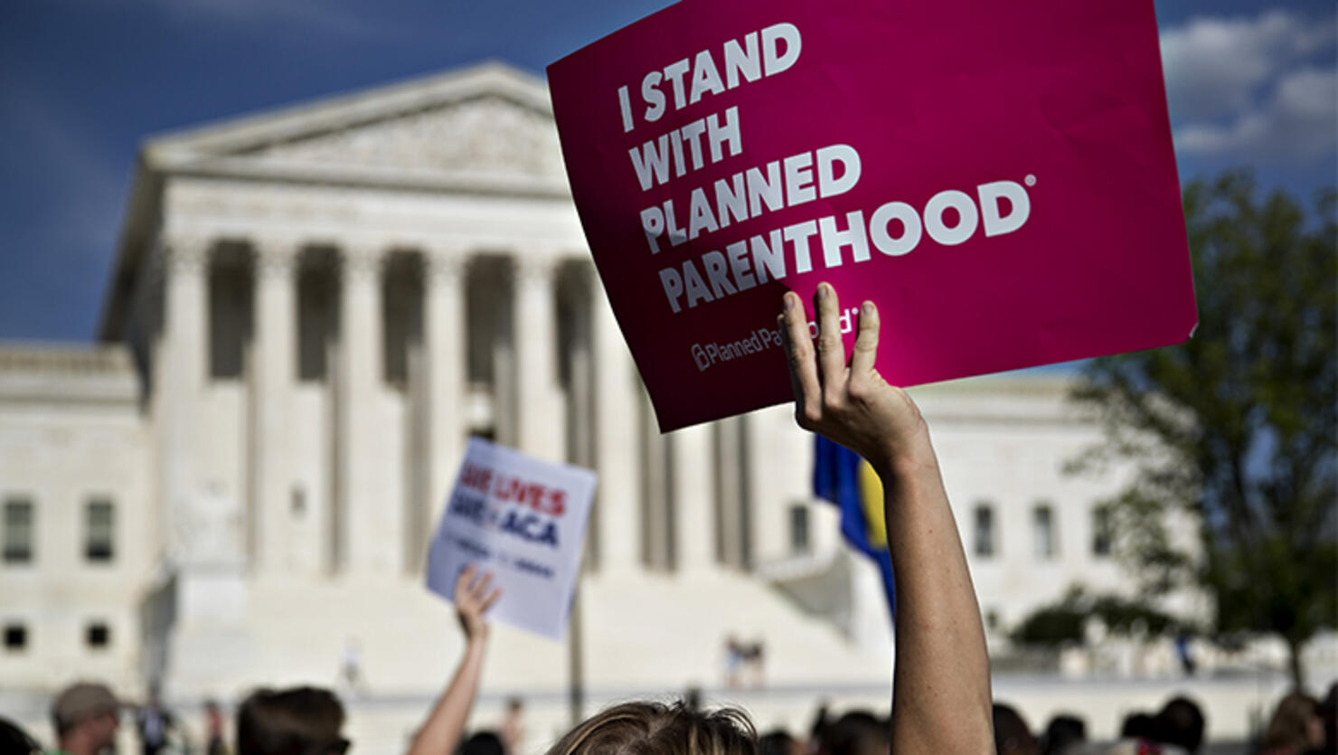 A demonstrator opposed to the Senate Republican health-care holds a sign that reads 'I Stand With Planned Parenthood' while marching near the U.S. Supreme Court in Washington, D.C