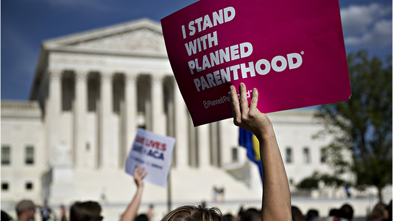 A demonstrator opposed to the Senate Republican health-care holds a sign that reads 'I Stand With Planned Parenthood' while marching near the U.S. Supreme Court in Washington, D.C