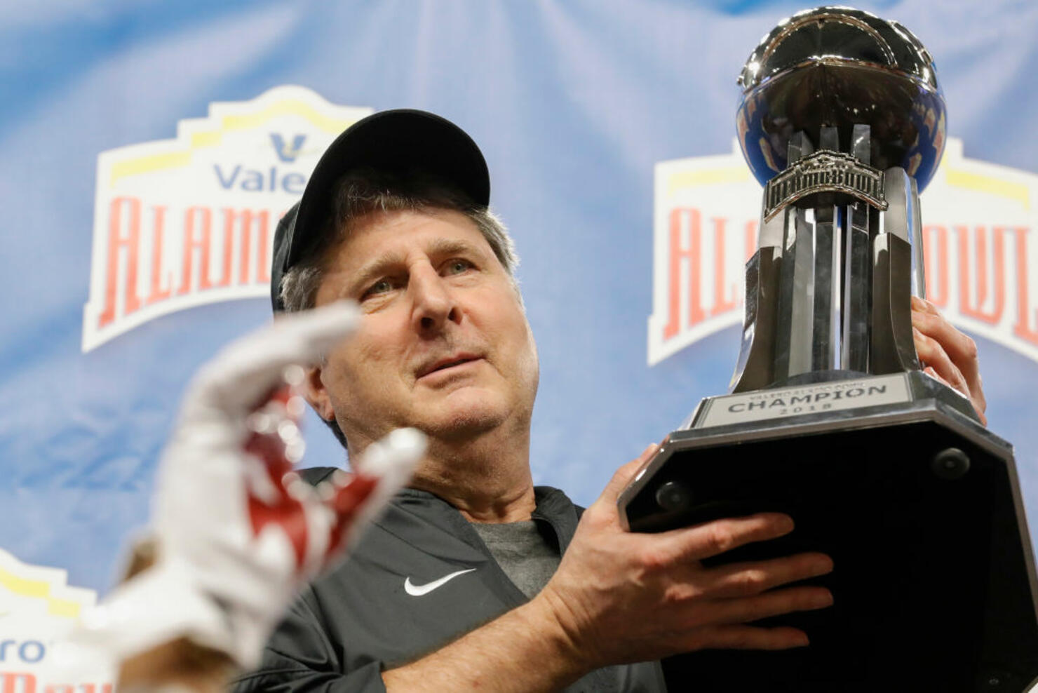 Head coach Mike Leach of the Washington State Cougars holds the championship trophy after the Valero Alamo Bowl 
