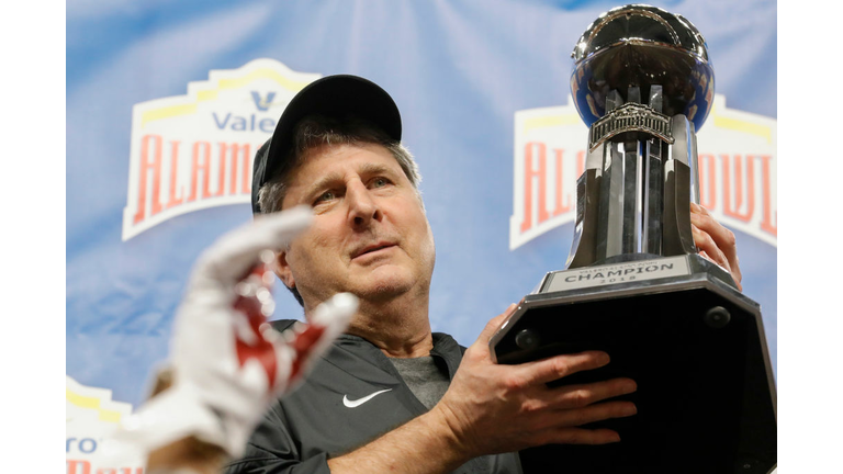 Head coach Mike Leach of the Washington State Cougars holds the championship trophy after the Valero Alamo Bowl 