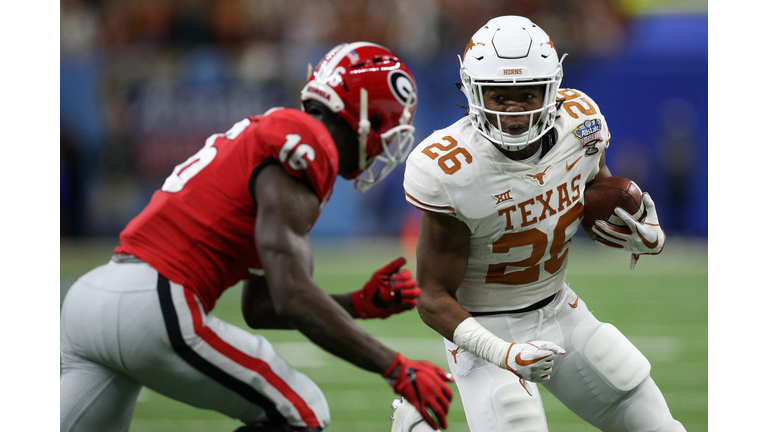 Keaontay Ingram of the Texas Longhorns avoids a tackle