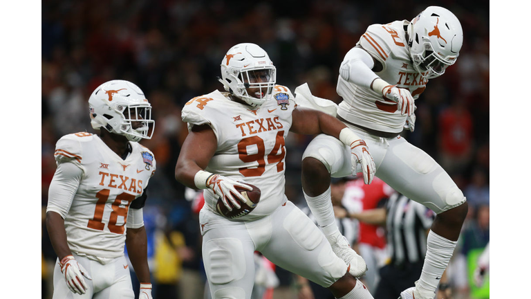 Gerald Wilbon of the Texas Longhorns reacts with teammates B.J. Foster and Davante Davis