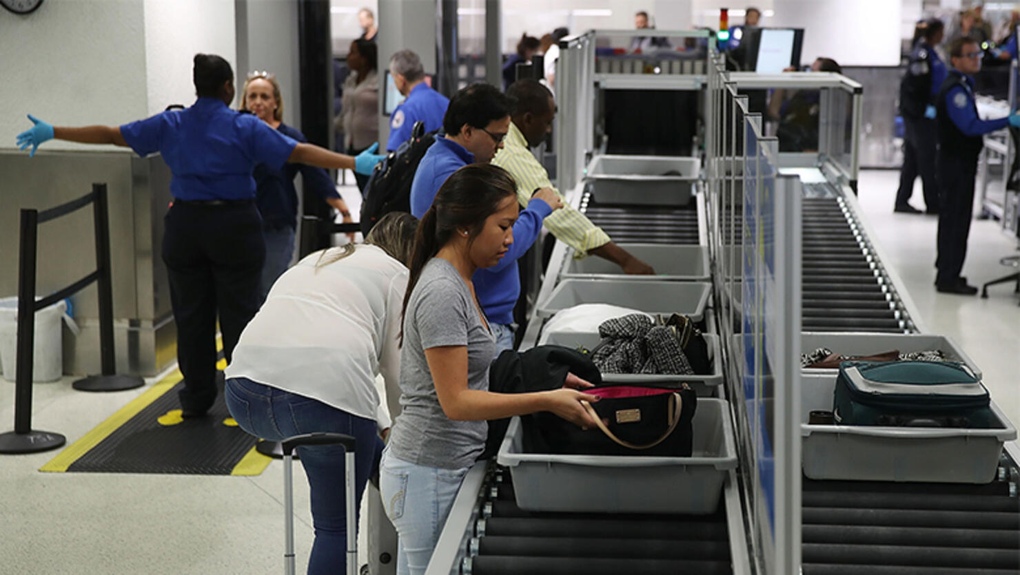 Travelers use the automated screening lanes funded by American Airlines and installed by the Transportation Security Administration at Miami International Airport