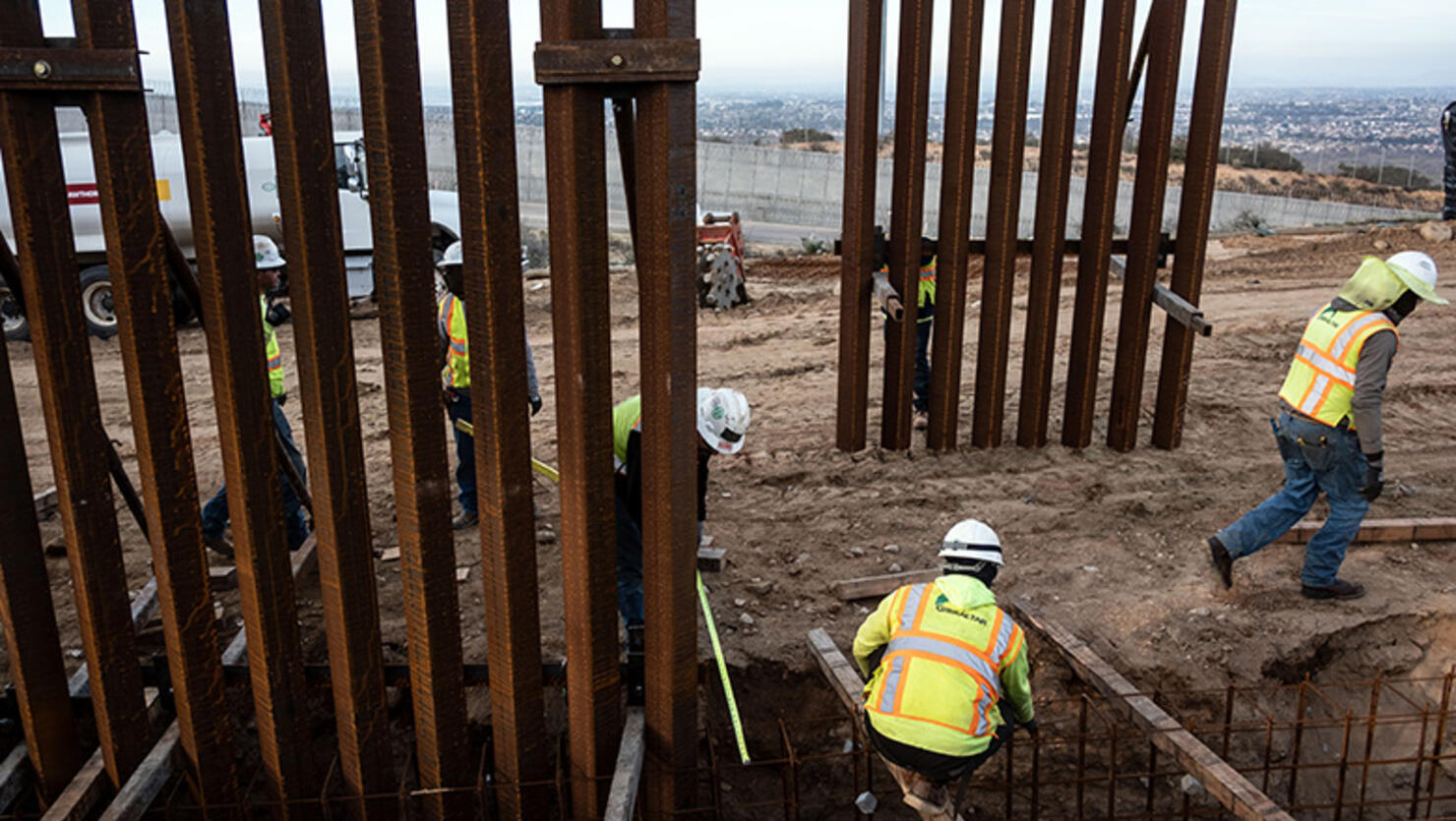 A construction crew works on replacing the US-Mexico border fence as seen from Tijuana, in Baja California state, Mexico