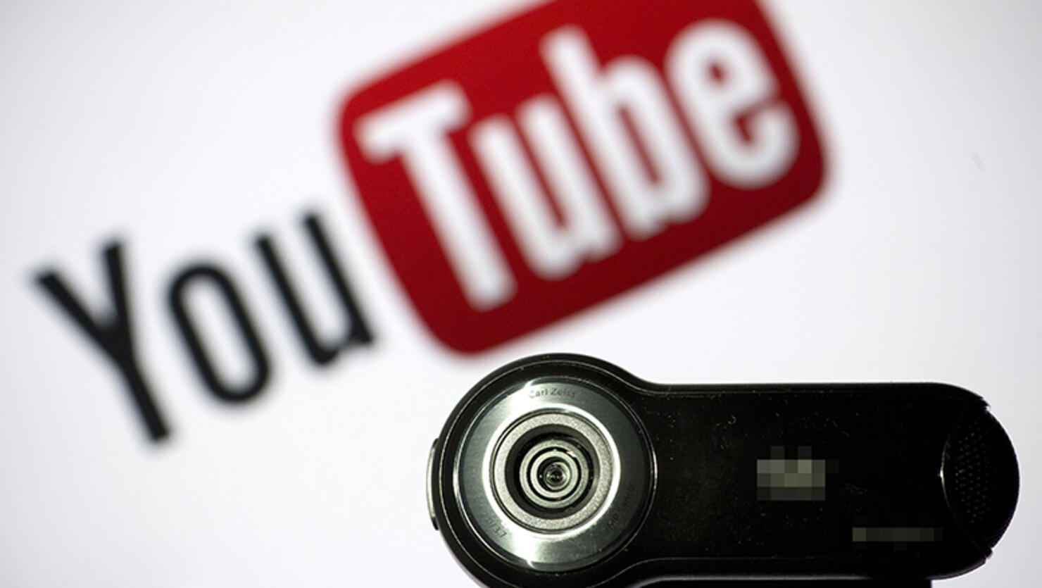 A webcam is positioned in front of YouTube's logo 