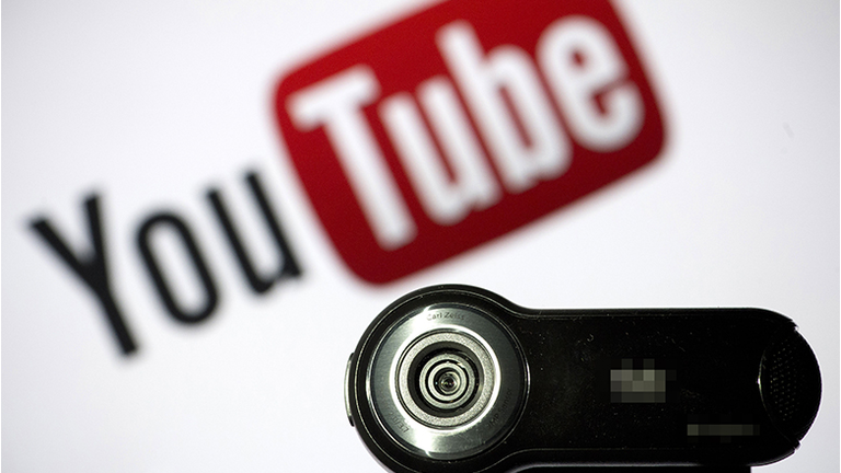 A webcam is positioned in front of YouTube's logo 