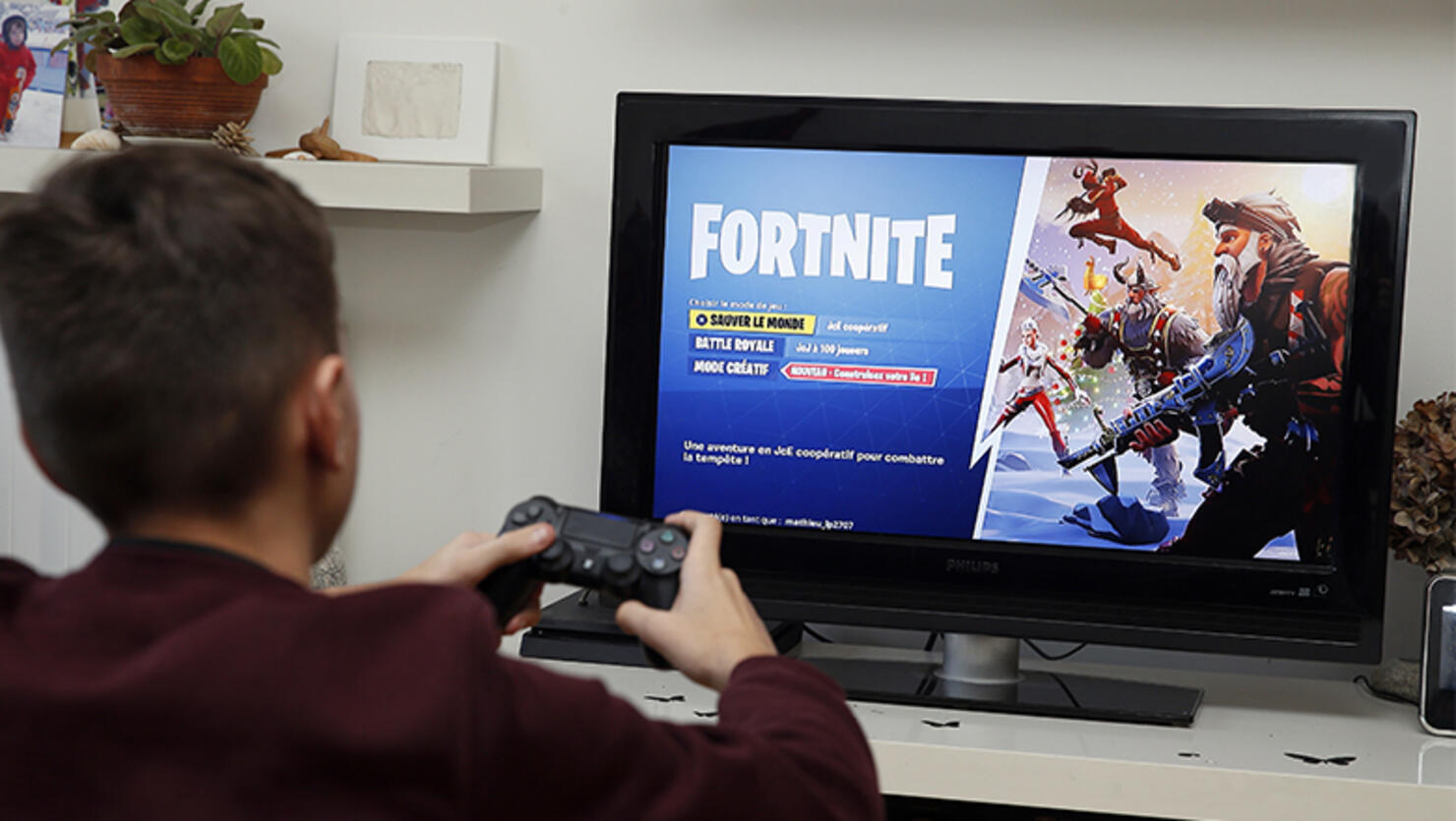 A gamer plays the video game 'Fortnite Battle Royale' developed by Epic Games on a Sony PlayStation game console PS4 Pro 