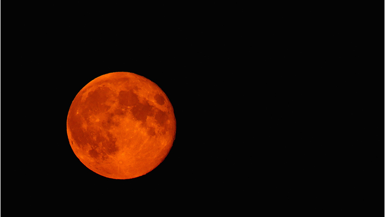 A blood red Super moon is seen rising in the sky