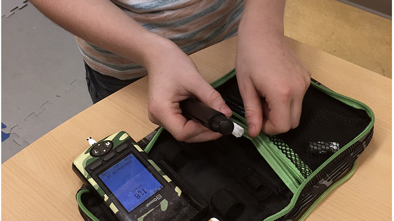 Dutch boy Ruben van As, 7, who has childhood diabetes, shows off his life-saving kit which he carries with him all the time and can show him immediately how high his blood sugar levels are and if he needs to adjust his insulin