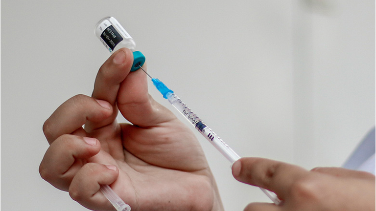 A woman prepares a syringe at a vaccination point against measles
