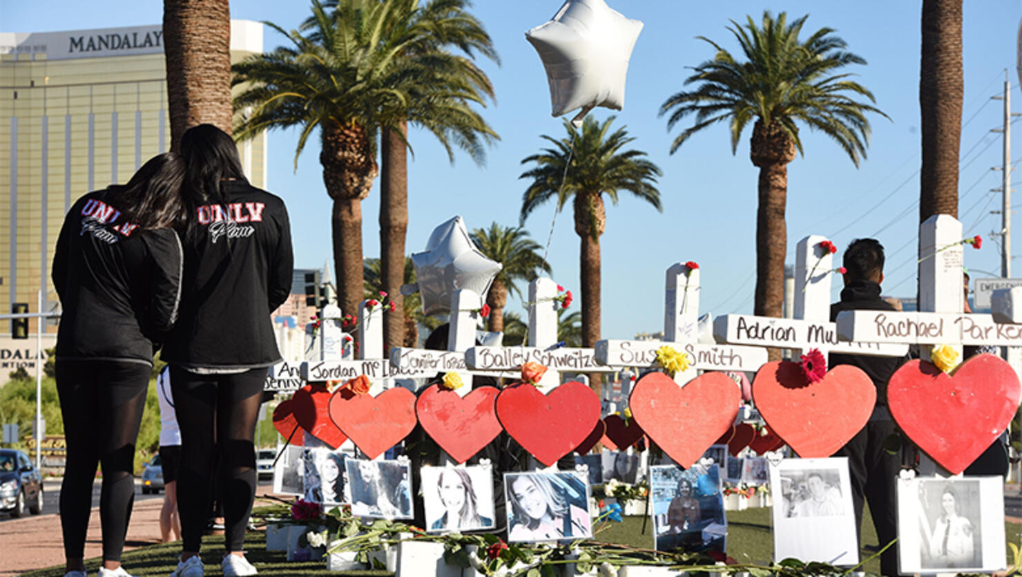 Members of the University of Las Vegas pom squad visit 58 white crosses for the victims of Sunday night's mass shooting on the Las Vegas Strip just south of the Mandalay Bay hotel