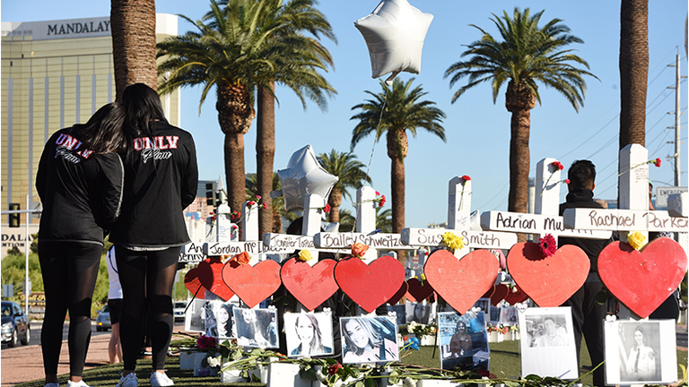 Members of the University of Las Vegas pom squad visit 58 white crosses for the victims of Sunday night's mass shooting on the Las Vegas Strip just south of the Mandalay Bay hotel