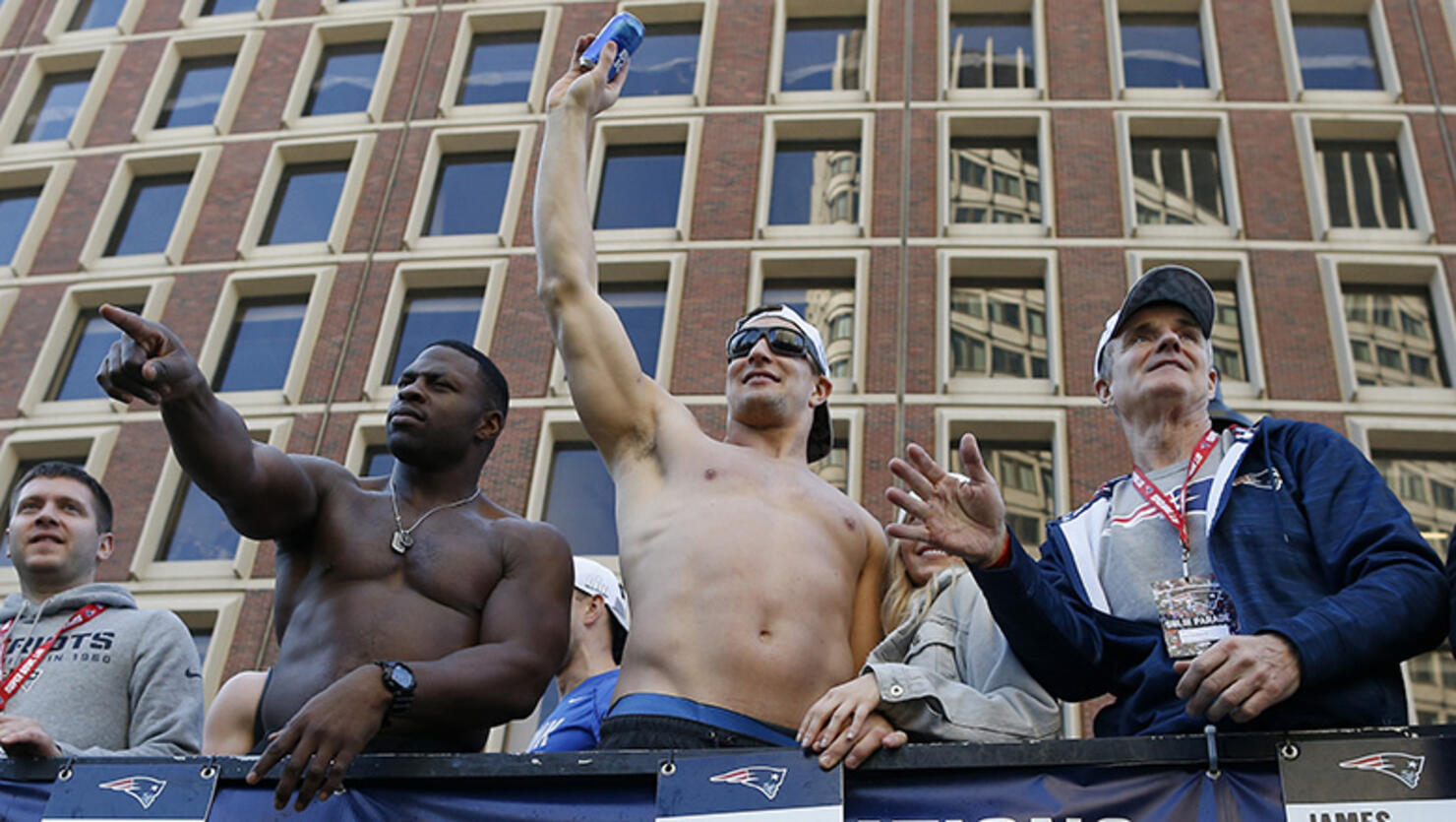 Rob Gronkowski, center, catches a beer that was thrown to him from the crowd during the New England Patriots Super Bowl LIII victory parade in Boston
