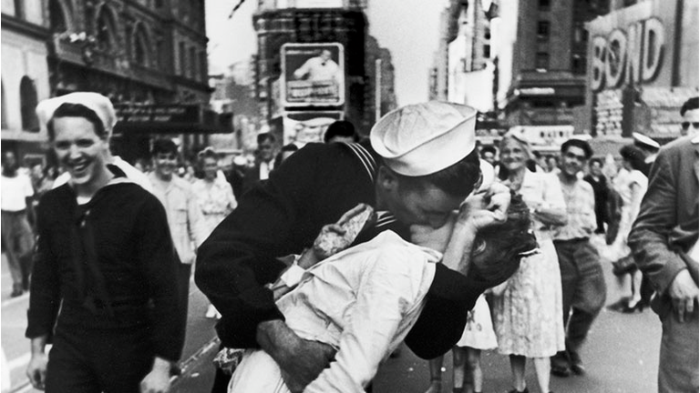  A jubilant American sailor clutching a white-uniformed nurse in a back-bending, passionate kiss as he vents his joy while thousands jam Times Square to celebrate the long awaited-victory over Japan