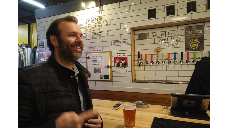 Matt with beer smiles