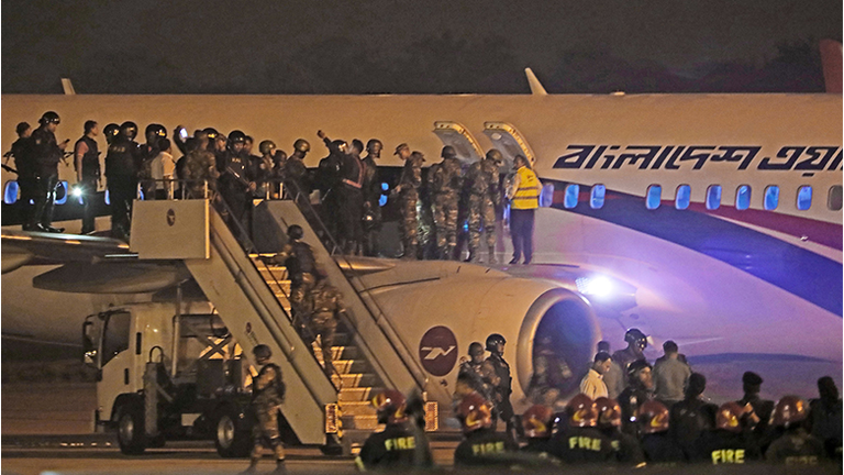 Bangladeshi security personnel stand guard near a Dubai-bound Bangladesh Biman plane on the tarmac of the Shah Amanat International Airport in Chittagong on February 24, 2019, following an emergency landing after a man apparently attempted to hijack the aircraft.