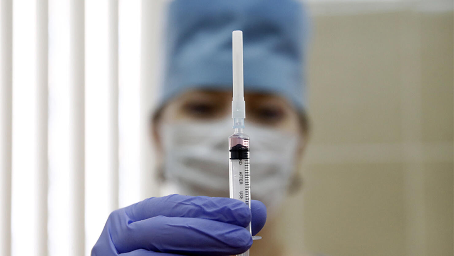 A medical staff worker with a syringe containing vaccine for measles and mumps