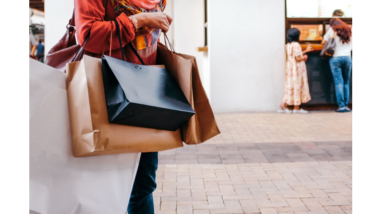 Midsection Of Woman Holding Shopping Bags