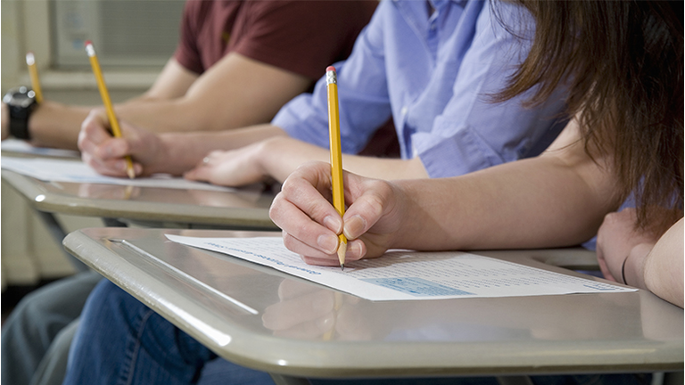 Students sitting at desks and writing
