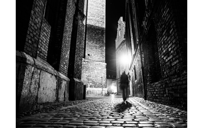 Illuminated cobbled street in old city by night