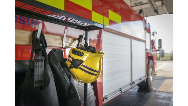 Firemans helmet hanging by fire engine in fire station