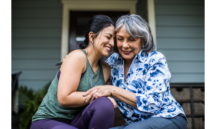 Senior woman and adult daughter laughing on porch