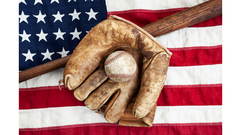 Directly Above Shot Of Baseball Bat With Ball And Glove On American Flag